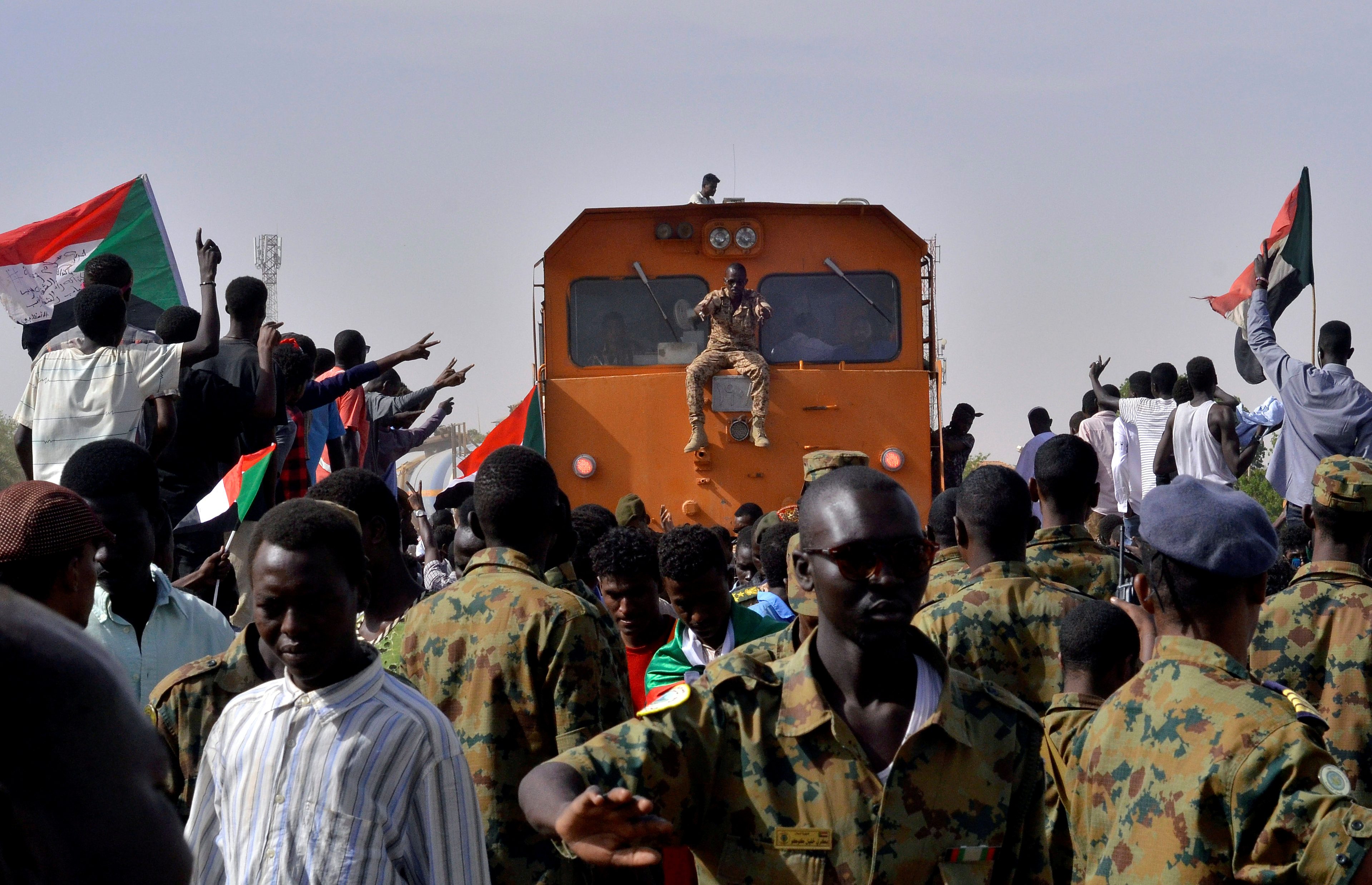عناصر من الجيش السوداني ومتظاهرون أمام مقر وزارة الدفاع