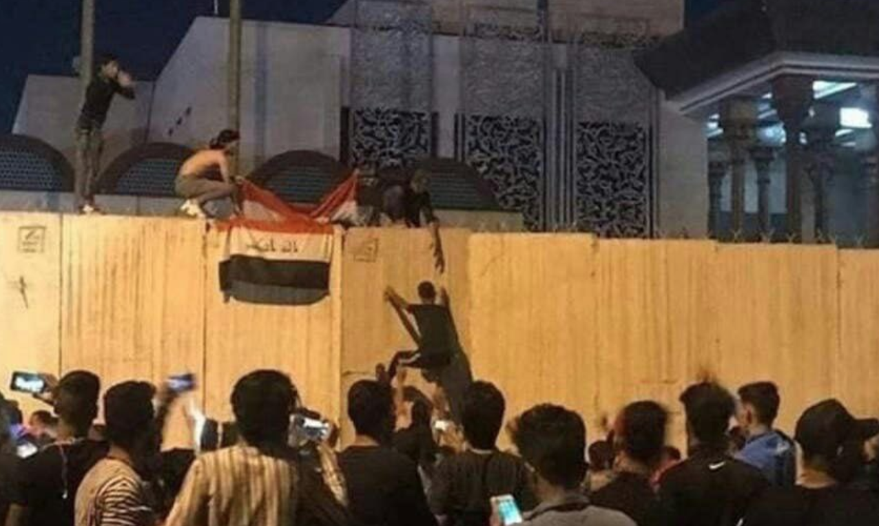 محتجون عراقيون يهاجمون قنصلية إيران في كربلاء ويرفعون عليها علم بلدهم
