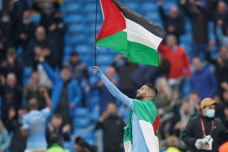 النجم الجزائري “محرز” يحتفل بلقب “البريمرليغ” بعلم فلسطين.. طاف به الملعب وإشادة واسعة على “تويتر” (فيديو)