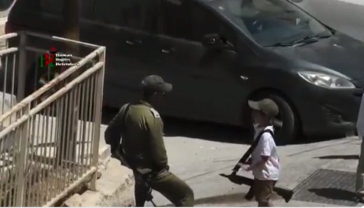فيديو لطفل إسرائيلي لم يتجاوز الـ7 يتجول في الخليل حاملاً السلاح.. جنود الجيش يحيطون به ويحمونه