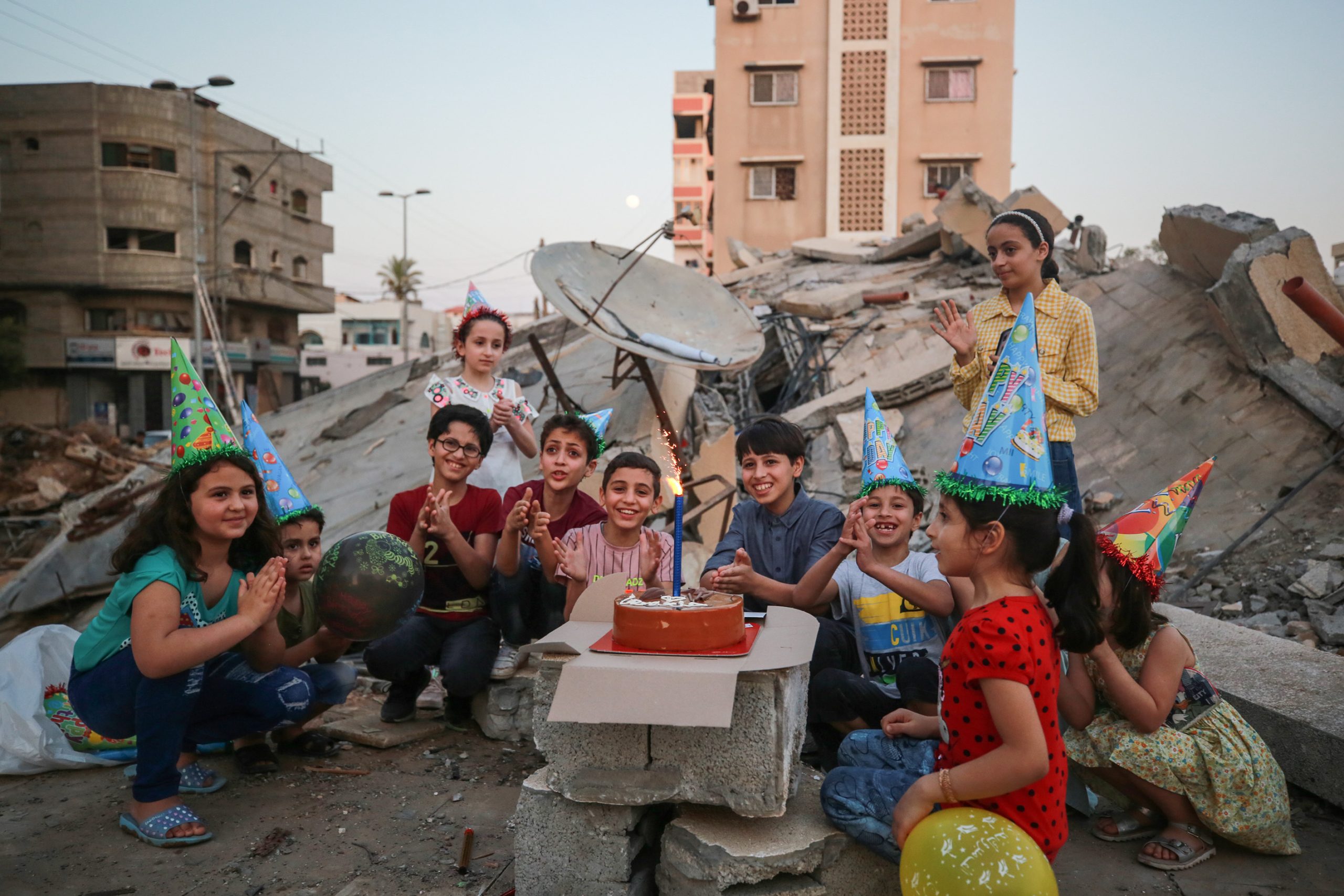 عائلة فلسطينية تحتفل بعيد ميلاد نجلها فوق ركام منزلها بغزة.. وحلاق يمارس مهنته على أنقاض بيته (صور)