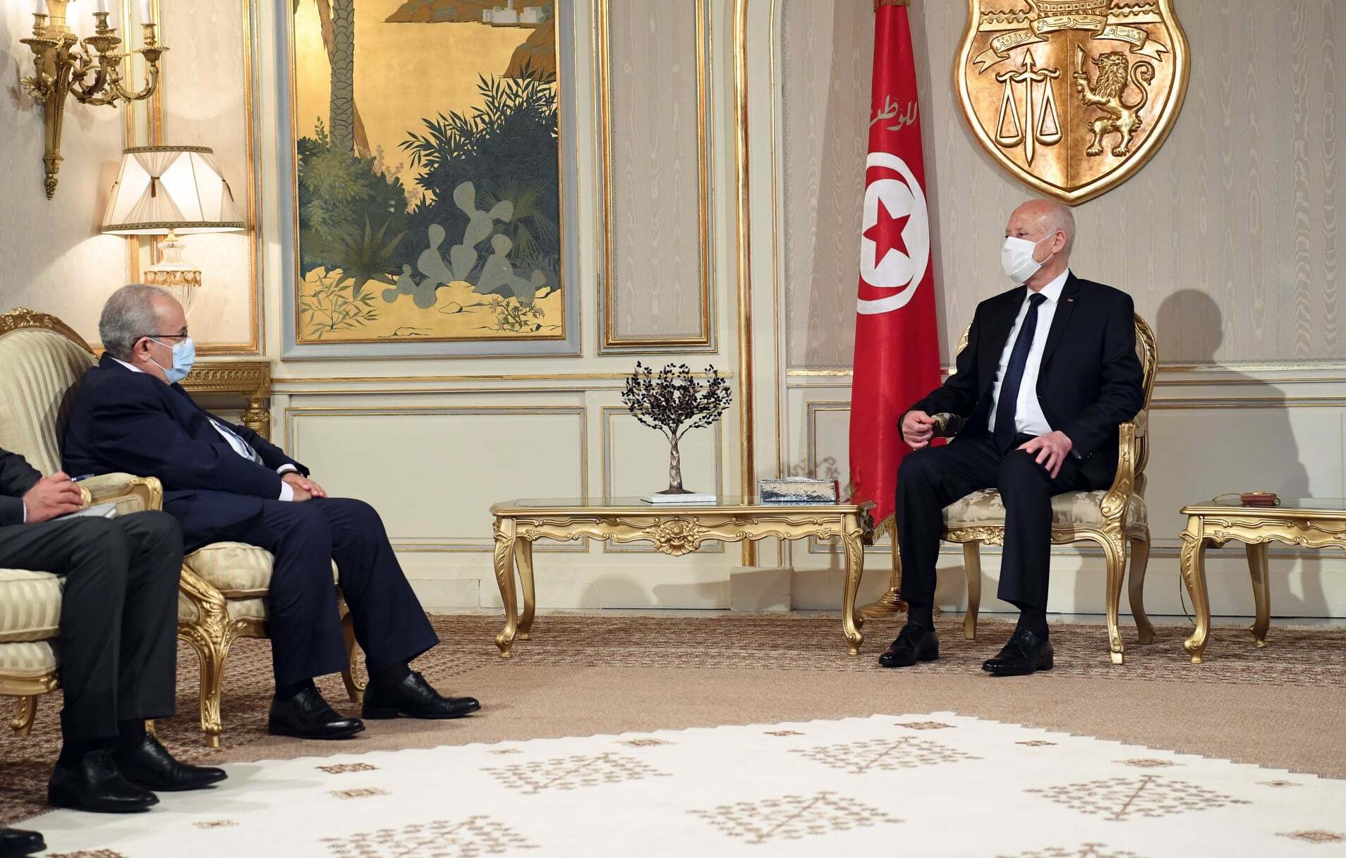وزير الخارجية الجزائري رمطان لعمامرة، إلى جوار الرئيس التونسي قيس سعيد/ الأناضول